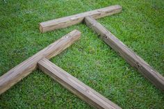 four pieces of wood laying in the grass on top of each other with nails sticking out of them