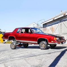 a red car parked in front of a building