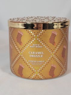 a candle that is sitting on a white surface with polka dots and gold trimmings