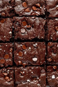 brownies with chocolate chips and sea salt on top are arranged in rows, one is cut into squares