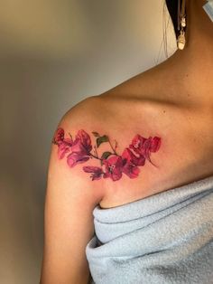 a woman's shoulder with red flowers on the left side of her arm and chest