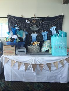 a baby shower table with blue and white items