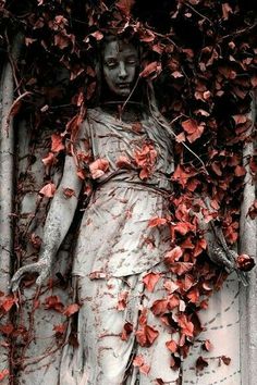 the statue is surrounded by vines and leaves