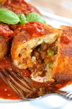 a close up of a plate of food with meat and tomato sauce on the side