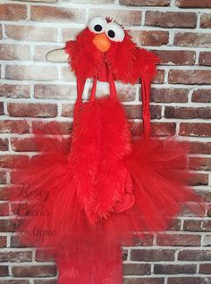 a sesame street costume hanging on a brick wall