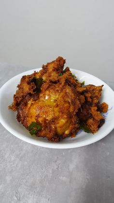 some fried food on a white plate sitting on a table