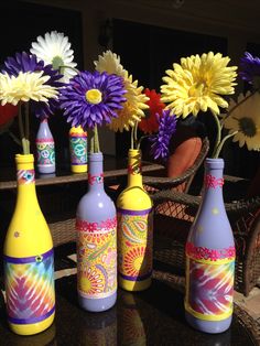 colorful vases with flowers in them sitting on a table