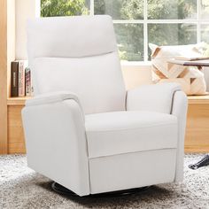 a white recliner chair sitting on top of a rug in front of a window