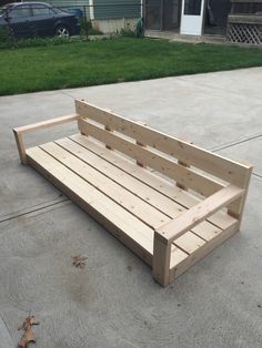 a wooden bench sitting in the middle of a driveway