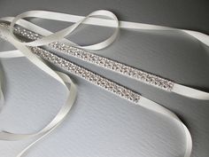 "This sparkly belt is made with the Premium Quality European Crystals appliqued on a 5/8\" wide double face satin ribbon. The length of the beading can be specified, please choose the length from the drop down menu during checkout. Available in gold or silver finish. - For the photo of the satin ribbon color options please take a look here: https://www.etsy.com/listing/225025505/satin-ribbon-swatches-ribbon-color?click_key=940a448d5b9f155300a35808a7a0ba11b9d03365%3A225025505&click_sum=d2690937&r Elegant Silver Bedazzled Sash, Elegant Silver Bedazzled Sashes, Elegant Bedazzled Silver Sash, Elegant Bedazzled Silver Sashes, Elegant Bedazzled Bridal Belt For Wedding, Elegant White Sashes With Rhinestones, Elegant Bedazzled Wedding Sash, Elegant White Belt With Rhinestones, Formal Fitted Sash With Rhinestones