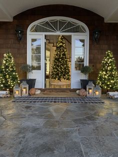 the front door is decorated with christmas trees and lanterns