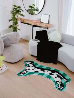 a living room with a cow rug on the floor and chairs in front of it