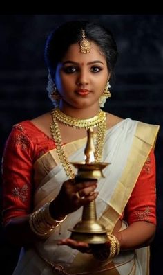 a woman in red and gold is posing for the camera with her hands on her chest