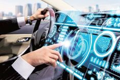 a man in a suit is driving a car and touching the screen with his hand