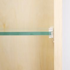 an open wooden door with green tape on the handle and bottom part of the door