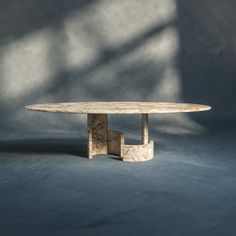 a marble table sitting on top of a blue floor next to a white wall with shadows