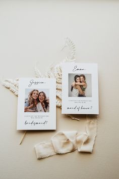 two wedding cards with the same photo on them next to some white flowers and ribbons