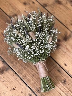 a bouquet of baby's breath tied with twine on top of a wooden floor