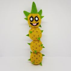 a crocheted pineapple stuffed animal sitting on top of a white surface