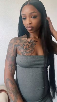 a woman with long black hair and tattoos on her chest is posing for the camera