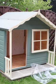 a small blue and white shed with windows