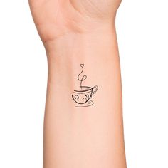 a woman's arm with a tattoo on it that has a coffee cup in the shape of a heart