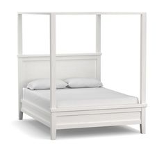 a white bed with four posts and pillows on the headboard, in front of a white background