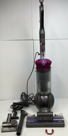 a close up of a vacuum cleaner on a white surface with other items around it