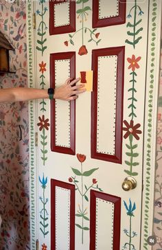 a person painting a door with flowers on it