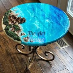 a blue table with an ocean scene on the top is shown in front of a window