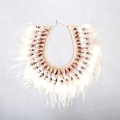 a white feather necklace hanging from a hook