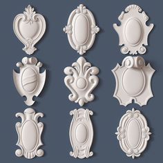 a set of white ornate frames and plaques