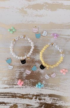 "Adorable 🐱kitty charm bracelets for all your cat lovers!! Bracelet is perfect for anyone any occasion! All orders come with 1 custom name beaded bracelet mixed with 24K gold bell charm and a kitty charm of your choice! You will have 7 colored beads and 4 different colored kitty charm to choose from. How to order: 1. Please select the bracelet size from the first drop down 2. Please select the bead color of your choise 3. In the personalization box - please enter the name you would like to plac Novelty White Bracelets With Charms, White Novelty Bracelets With Charms, Cute Hypoallergenic Charm Bracelet For Birthday, White Kawaii Charm Bracelet Gift, Cute White Charm Bracelet For Birthday, Cute Hypoallergenic Charm Bracelet For Friendship, Handmade White Kawaii Charm Bracelet, Customized Cute Charm Bracelet, Cute Hypoallergenic Charm Bracelet With Round Beads