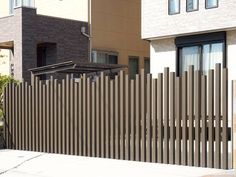 a tall wooden fence sitting in front of a building next to a parking meter and fire hydrant