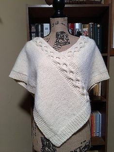 a white knitted sweater sitting on top of a mannequin