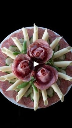 an overhead view of a platter filled with meat and cheese, as well as flowers