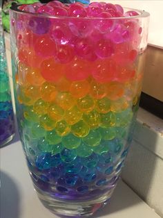 a glass filled with lots of different colored beads