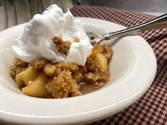 a close up of a bowl of food on a table with a fork and napkin