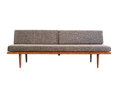 a gray couch sitting on top of a wooden frame