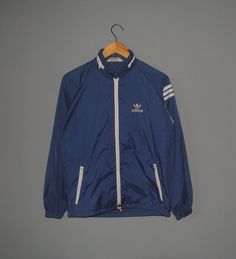 Up for sale Vintage 80s Adidas Trefoil Slim Fit light raincoat Used raincoat, Show sign of wear, Overall still in good vintage condition (Please refer picture) Tag size--Not available, Fit like Adult Small with actual measurement taken when lying flat armpit 20.5 inches and 24 inches in total lenght (Approx) Please note that vintage sizing is not the same as modern sizing. Always go by the measurements we provide and compare them to an item that fits you well. Feel free to message me for measure Vintage Three Stripes Track Jacket For Winter, Vintage Winter Track Jacket With Three Stripes, Vintage Three Stripes Winter Track Jacket, Vintage Nylon Track Jacket For Winter, Three Stripes Windbreaker For Winter Streetwear, Hooded Three-stripes Windbreaker For Streetwear, Vintage Windbreaker For Fall Sports, Vintage Spring Sports Windbreaker, Vintage Nylon Track Jacket For Streetwear