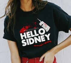 a woman wearing a t - shirt that says hello sidney with blood splatters on it