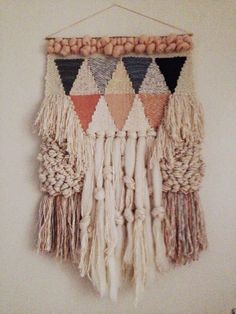 a wall hanging made out of yarn and wood beads with fringes on the ends