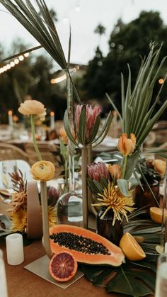 a table topped with lots of different types of fruits and flowers on top of it