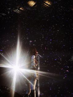 a woman standing on top of a stage holding a microphone