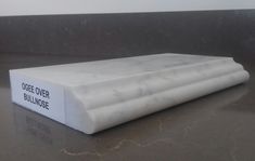 a white mattress sitting on top of a counter next to a wall with writing on it