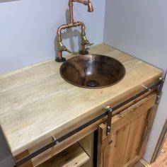 a bathroom sink sitting under a faucet on top of a wooden countertop