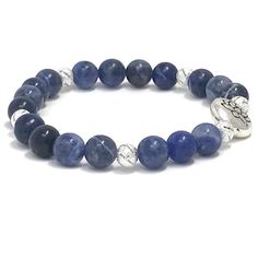 Sodalite gemstones bracelet. Sodalite emits an easy, tranquil energy that clears the mind and elicits deep thought, expanding the ability to arrive at logical conclusions based on rational consideration. It enhances one’s powers of analysis, intuition, observation and creativity, and strengthens self-discipline, efficiency and organization Highlights;- 8mm high quality sodalite beads- Silver plated Lotus Charm- 6mm silver plated metal beads**Due to the nature of the natural stones, all stones wi Blue Spiritual Stretch Bracelet, Spiritual Blue Stretch Bracelet, Blue Spiritual Stretch Bracelet For Everyday, Spiritual Sapphire Beaded Gemstone Bracelets, Spiritual Sapphire Beaded Bracelets With Natural Stones, Spiritual Lapis Lazuli Crystal Bracelet For Healing, Silver Lapis Lazuli Beaded Bracelets For Healing, Spiritual Blue Bracelets For Everyday, Spiritual Blue Bracelet For Everyday