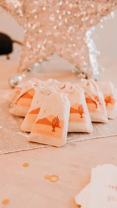 small bags sitting on top of a table with gold confetti around the edges