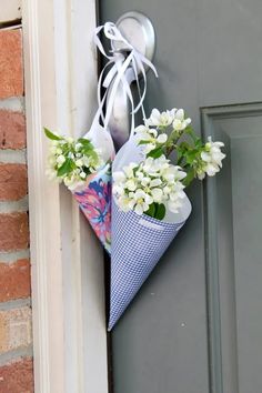 an umbrella shaped flower pot hanging on the side of a door with flowers in it