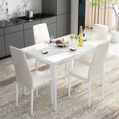 a white dining table and chairs in a room